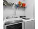 Bright laundry room with front loading washer and dryer and storage shelf at 1203 Desmond St, Port Charlotte, FL 33952