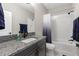 Bathroom featuring granite countertops, a tub with a shower, and dark wood cabinets at 14215 Swiss Bridge Dr, Riverview, FL 33579