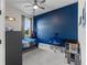 Bright bedroom with blue accent wall, modern desk, and comfortable furnishings at 14215 Swiss Bridge Dr, Riverview, FL 33579