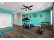 Bright gym with modern equipment, wood floors, and fresh, vibrant turquoise walls at 14215 Swiss Bridge Dr, Riverview, FL 33579