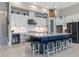 A modern kitchen features white cabinetry, stainless appliances, a large island, and stylish lighting at 14215 Swiss Bridge Dr, Riverview, FL 33579
