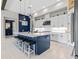 A modern kitchen features white cabinetry, stainless appliances, a large island, and stylish lighting at 14215 Swiss Bridge Dr, Riverview, FL 33579
