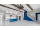 Open-concept living space boasts a gourmet kitchen, tile floors, and a staircase with modern lighting at 14215 Swiss Bridge Dr, Riverview, FL 33579