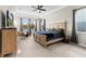 Bright main bedroom featuring a tray ceiling, large windows, and a cozy, neutral color scheme at 14215 Swiss Bridge Dr, Riverview, FL 33579