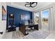 Well-lit office with a dark blue accent wall, modern desk setup, and carpet creates a professional workspace at 14215 Swiss Bridge Dr, Riverview, FL 33579