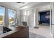 Bright home office featuring a large window, modern desk, and a view into a stylish blue accent-walled room at 14215 Swiss Bridge Dr, Riverview, FL 33579