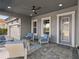 Covered outdoor patio offers comfortable seating, ceiling fan, and a view of the home's exterior at 14215 Swiss Bridge Dr, Riverview, FL 33579