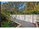 Backyard view with a peaceful gravel pathway and wood raised flower bed next to a modern white fence at 2307 Dakota Rock Dr, Ruskin, FL 33570