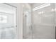 Modern glass enclosed shower with tile walls and floors and a view into the bedroom at 4306 Big Sky Dr, Spring Hill, FL 34604