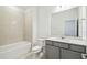 Bathroom with shower-tub combo, gray vanity, and modern lighting at 4306 Big Sky Dr, Spring Hill, FL 34604