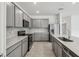 Modern kitchen featuring stainless steel appliances, grey cabinets, and spacious countertops at 4306 Big Sky Dr, Spring Hill, FL 34604
