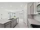 Bright, open kitchen with an island sink, stainless dishwasher, and gray cabinets overlooks the adjacent living space at 4306 Big Sky Dr, Spring Hill, FL 34604