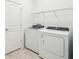 Bright laundry room with a door, wire shelving, and white washer and dryer at 4306 Big Sky Dr, Spring Hill, FL 34604