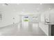 Bright living room features white walls, light gray tile floor, natural light, and a view of kitchen island at 4306 Big Sky Dr, Spring Hill, FL 34604