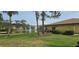 Home backyard with lush green grass, small lake with a fountain, and exterior elevation of the building at 5849 Park N St # 201, St Petersburg, FL 33709