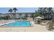 Community pool with lounge chairs, tables, and building exterior at 5849 Park N St # 201, St Petersburg, FL 33709
