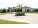 A circular driveway and landscaped front yard lead to a charming single story home with a columned front porch at 6367 Foxbrook Trl, Parrish, FL 34219