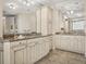 Bathroom boasts dual vanities, granite countertops, decorative mirrors, and travertine floors at 3910 Gulf Blvd # 400, St Pete Beach, FL 33706