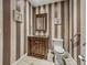 Powder room featuring striped wallpaper and dark wood vanity at 3910 Gulf Blvd # 400, St Pete Beach, FL 33706