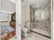 Bathroom featuring a glass enclosed shower with a bench and grab bars, and a toilet at 3910 Gulf Blvd # 400, St Pete Beach, FL 33706