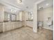 Bathroom boasts dual vanities with granite countertops and travertine tile flooring at 3910 Gulf Blvd # 400, St Pete Beach, FL 33706
