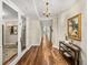 Long entrance hallway featuring hardwood floors and stylish decor, with chandelier, leading to rooms at 3910 Gulf Blvd # 400, St Pete Beach, FL 33706