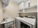 Bright laundry room featuring Samsung washer and dryer and ample white cabinet storage space at 3910 Gulf Blvd # 400, St Pete Beach, FL 33706