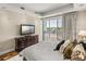 Bright primary bedroom with a large dresser, hard wood floors, and balcony access with waterfront views at 3910 Gulf Blvd # 400, St Pete Beach, FL 33706