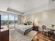 Bright primary bedroom featuring a tray ceiling, wood floors, area rug, and balcony access with waterfront views at 3910 Gulf Blvd # 400, St Pete Beach, FL 33706