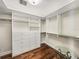 Walk-in closet featuring custom shelving, drawers, hanging rods and wood-look flooring at 3910 Gulf Blvd # 400, St Pete Beach, FL 33706