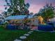 Inviting backyard featuring a covered patio, hot tub, string lights, and lush green lawn perfect for outdoor enjoyment at 6145 55Th N Ave, St Petersburg, FL 33709