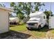 Spacious grassy backyard with a white RV parked on the side, along with an outdoor patio area at 6145 55Th N Ave, St Petersburg, FL 33709