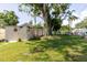 Large backyard with a shed, mature trees, and a comfortable hammock area at 6145 55Th N Ave, St Petersburg, FL 33709