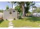 Large backyard featuring a shed, mature trees, and stepping stones at 6145 55Th N Ave, St Petersburg, FL 33709