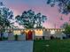 Charming home featuring string lights, a vibrant red door with a wreath, and a well-maintained front yard at 6145 55Th N Ave, St Petersburg, FL 33709