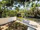 Backyard view with water access, showcasing a white fence and a glimpse of the home's architecture at 7418 Bay Dr, Tampa, FL 33635