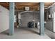Unfinished basement featuring concrete flooring, laundry area, and painted support beams at 7418 Bay Dr, Tampa, FL 33635