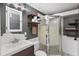 Modern bathroom with industrial-style lighting, shelving, and frameless glass shower doors at 7418 Bay Dr, Tampa, FL 33635