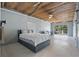 Spacious bedroom features unique ceiling design, neutral walls, and sliding glass doors to the outdoors at 7418 Bay Dr, Tampa, FL 33635