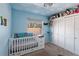 Charming Bedroom with a bright blue accent wall, a crib, and ample natural light at 7418 Bay Dr, Tampa, FL 33635
