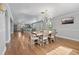 Open dining area flowing into the kitchen, featuring hardwood floors and a modern light fixture at 7418 Bay Dr, Tampa, FL 33635