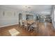 Dining area with chandelier, wainscotting, and wood floors that seamlessly connects to the kitchen at 7418 Bay Dr, Tampa, FL 33635