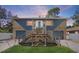 Unique split-level home featuring stone accents, dual garages, and a welcoming elevated front entry at 7418 Bay Dr, Tampa, FL 33635