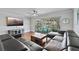 Cozy living room featuring hardwood floors, a ceiling fan, and a screened lanai at 7418 Bay Dr, Tampa, FL 33635