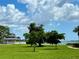 Picturesque park with lush green grass, mature trees, a white gazebo and bay views at 7418 Bay Dr, Tampa, FL 33635