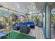 Enclosed patio features comfortable seating, ceiling fans, and screens with a wooded view at 7418 Bay Dr, Tampa, FL 33635