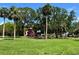Colorful playground with a slide, set in a lush green park with palm trees at 7418 Bay Dr, Tampa, FL 33635