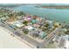 Aerial view of a colorful neighborhood, white sand beach, and blue ocean, with the home indicated by a purple arrow at 106 7Th Ave, St Pete Beach, FL 33706