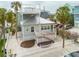 Charming coastal home with two stories, a metal roof, a deck and white picket fence at 106 7Th Ave, St Pete Beach, FL 33706