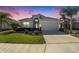 Charming single-Gathering home featuring lush landscaping, a two-car garage, and a cozy front porch at 12425 Glenridge Ln, Parrish, FL 34219